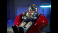 Twiki and Dr. Theopolis seated on a red bean chair[1] in Rogers' Apartment (BR25: Film, "Awakening").