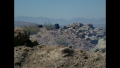 [Photo 2]: A plane seen off in the horizon, behind the nomads that follow William "Buck" Rogers and Duke Danton following their crash in the Sea of Stone (BR25: "Planet of the Slave Girls").